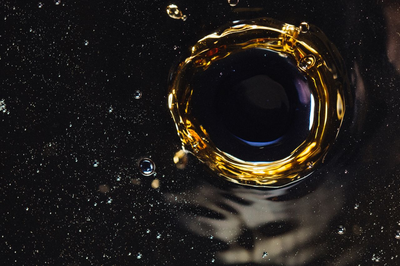 >Closeup of water funnel and splashes created by drop on bubbling surface as background